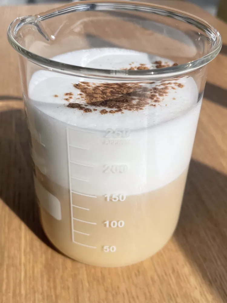 Café con leche y canela servido en un vaso de precipitados